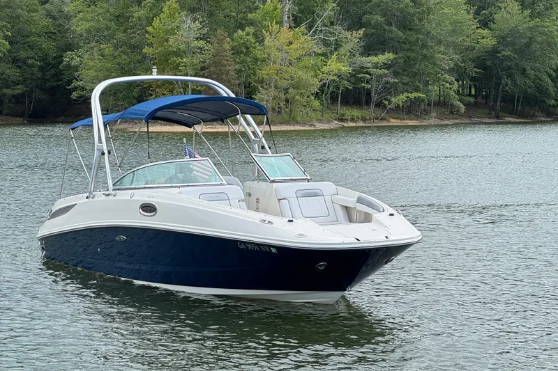 Slide: The Image of 2009 Sea Ray 280 Sundeck boat on a serene lake with lush green trees. - 21