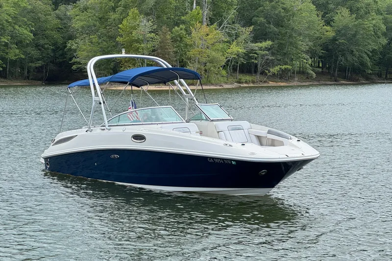Slide: The Image of 2009 Sea Ray 280 Sundeck boat on a serene lake with lush green trees. - 23