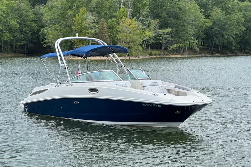 Slide: The Image of 2009 Sea Ray 280 Sundeck boat on a serene lake with lush green trees. - 24