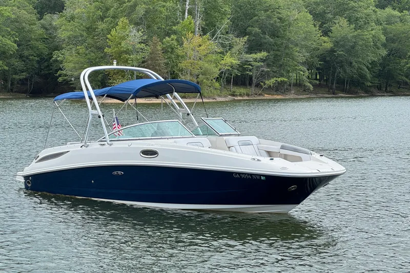 Slide: The Image of 2009 Sea Ray 280 Sundeck boat on a serene lake with lush green trees. - 25