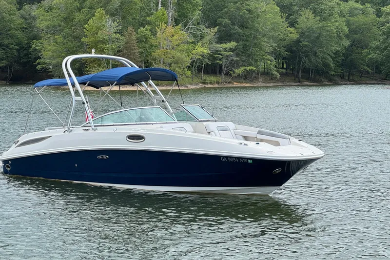 Slide: The Image of 2009 Sea Ray 280 Sundeck boat on a serene lake with lush green trees. - 26