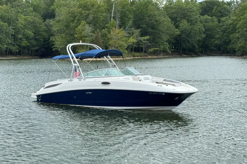 Slide: The Image of 2009 Sea Ray 280 Sundeck boat on a calm lake with lush green trees. - 27