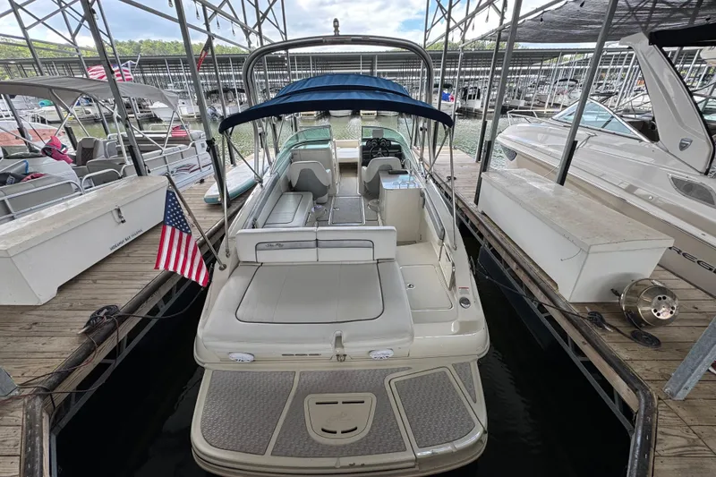 Slide: The Image of 2009 Sea Ray 280 Sundeck docked, featuring spacious seating and American flag. - 28