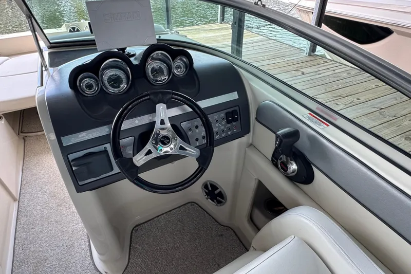 Slide: The Image of 2009 Sea Ray 280 Sundeck helm with steering wheel and control panel, dockside view. - 35