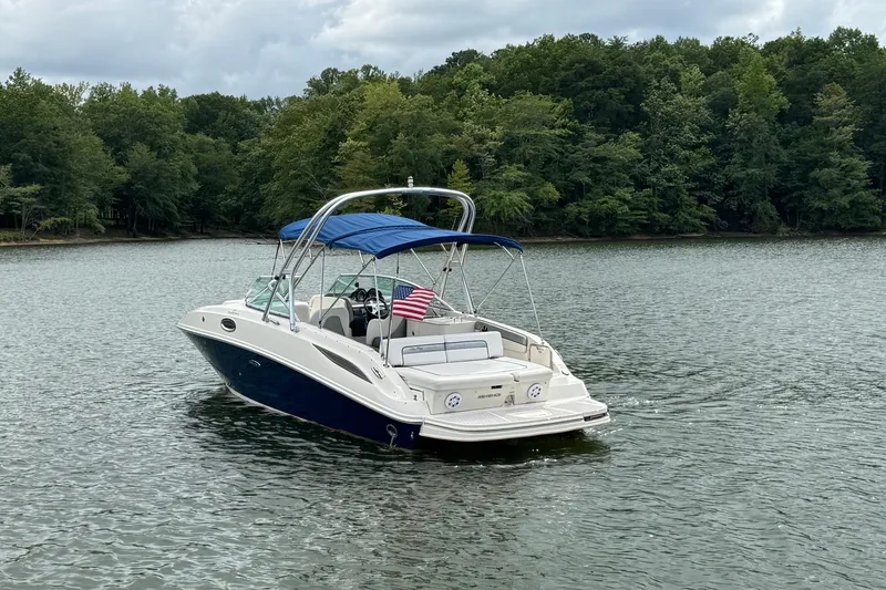 Slide: The Image of 2009 Sea Ray 280 Sundeck boat on a serene lake with lush green trees. - 4