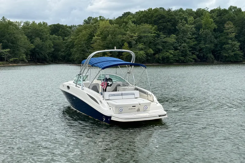 Slide: The Image of 2009 Sea Ray 280 Sundeck boat on a calm lake with forested shoreline. - 5