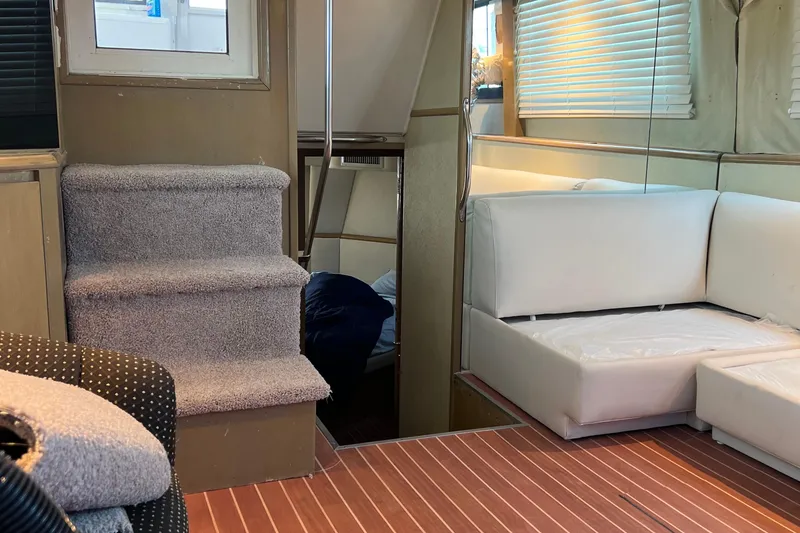 Slide: The Image of Interior of 1991 Hatteras 52 Cockpit Motor Yacht with carpeted stairs and white seating. - 10