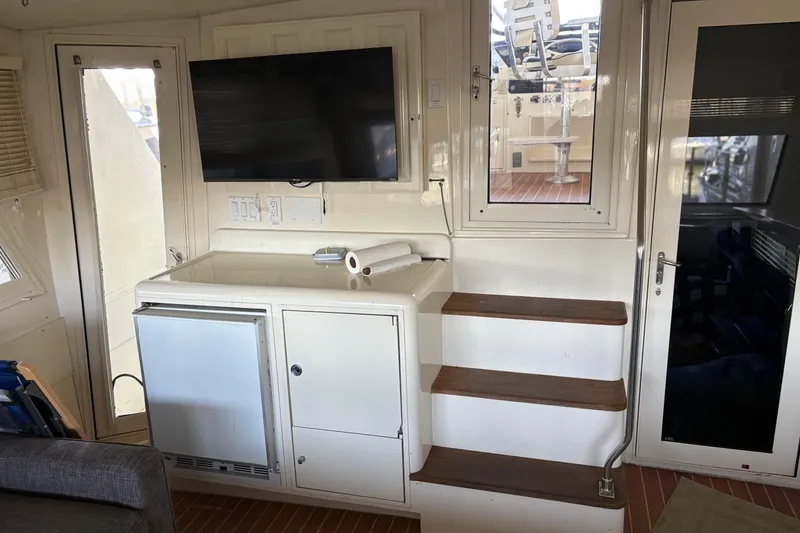 Slide: The Image of Interior of 1991 Hatteras 52 Cockpit Motor Yacht with TV, stairs, and cabinetry. - 11