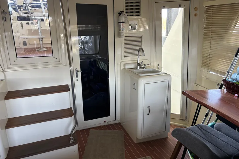 Slide: The Image of Interior of 1991 Hatteras 52 Cockpit Motor Yacht with sink, stairs, and seating area. - 12