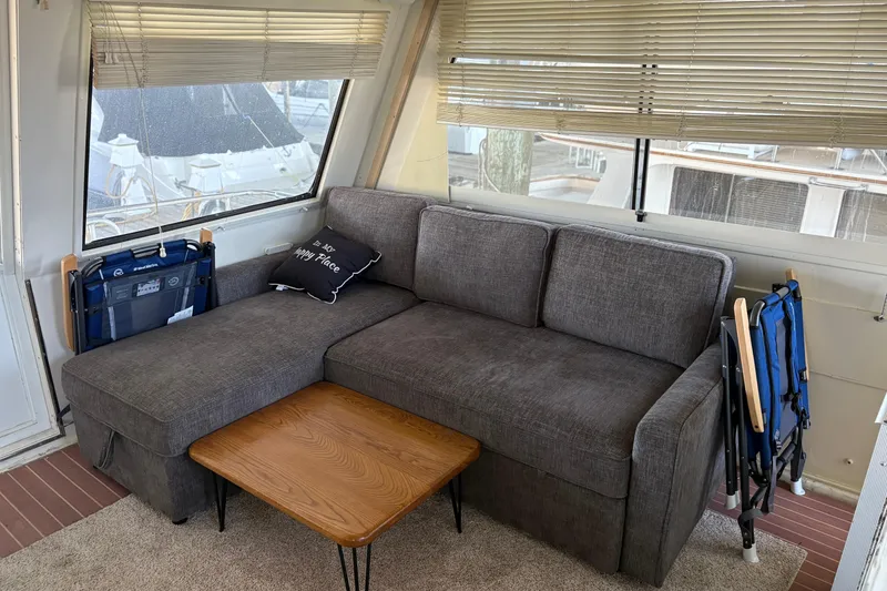 Slide: The Image of Cozy interior of 1991 Hatteras 52 Cockpit Motor Yacht with gray sofa and wooden table. - 13