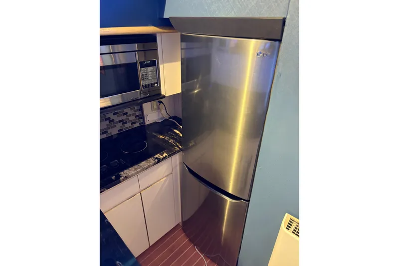Slide: The Image of Modern kitchen with stainless steel appliances on a 1991 Hatteras 52 Cockpit Motor Yacht. - 17