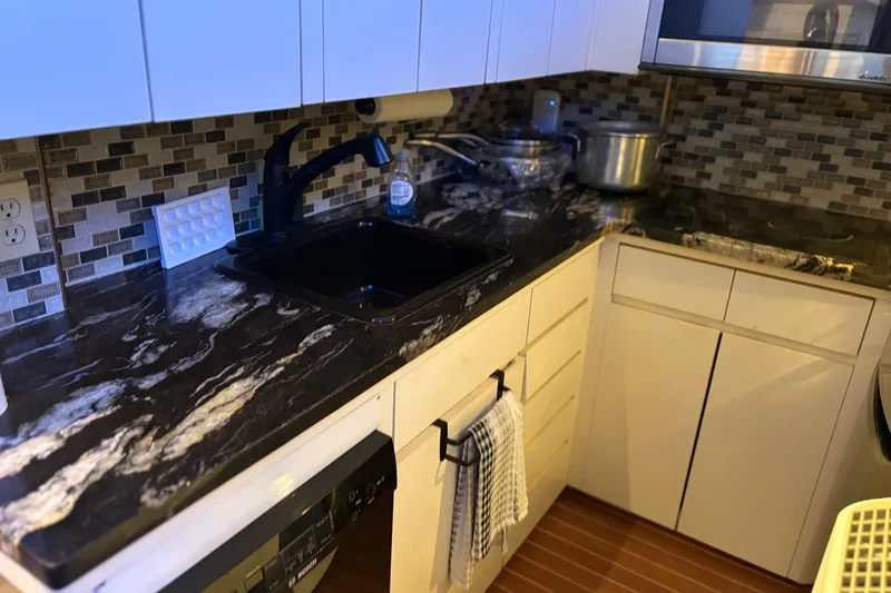 Slide: The Image of Modern kitchen in 1991 Hatteras 52 Cockpit Motor Yacht with marble countertops and tiled backsplash. - 18