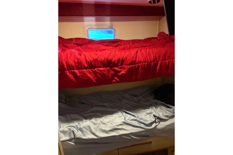 Slide: The Image of Bunk beds with red and gray bedding inside a 1991 Hatteras 52 Cockpit Motor Yacht. - 23