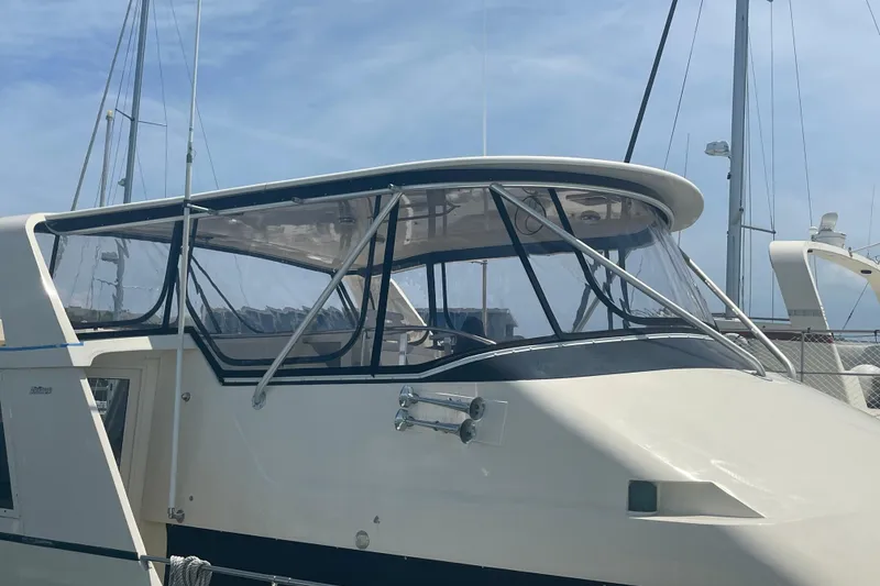 Slide: The Image of 1991 Hatteras 52 Cockpit Motor Yacht with sleek design and clear windows, docked at marina. - 3