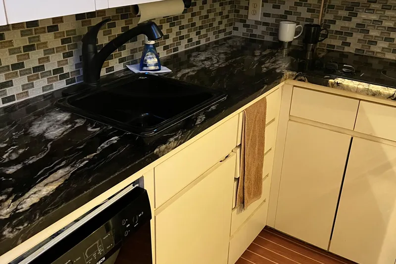 Slide: The Image of Kitchen area of 1991 Hatteras 52 Cockpit Motor Yacht with black marble countertop. - 5