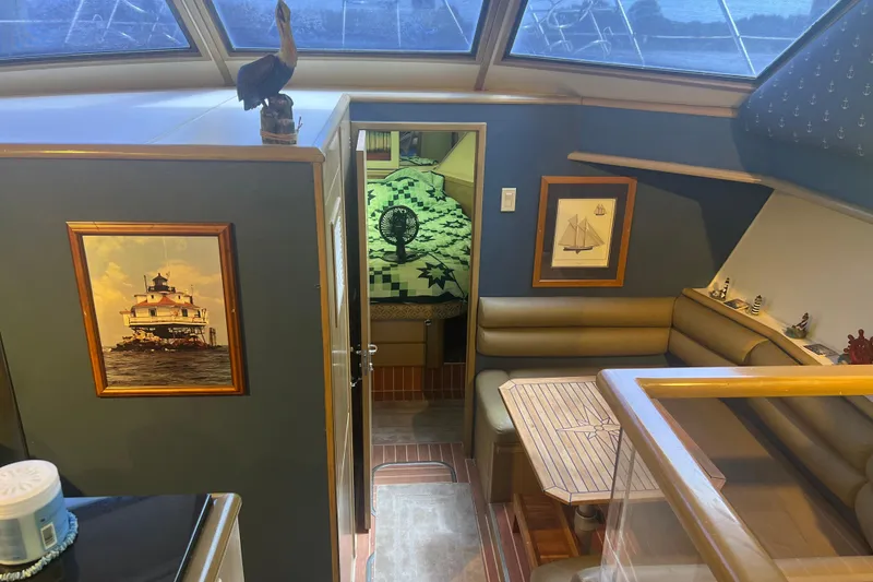 Slide: The Image of Interior of 1991 Hatteras 52 Cockpit Motor Yacht with nautical decor and seating area. - 9