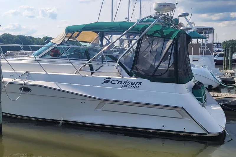 The Image of 1989 Cruisers 3670 yacht docked at marina with green canopy and clear skies. - 0