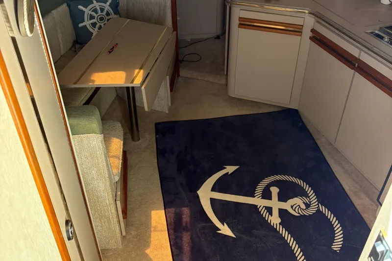 Slide: The Image of Interior of 1989 Cruisers 3670 yacht with nautical decor and anchor-themed rug. - 12