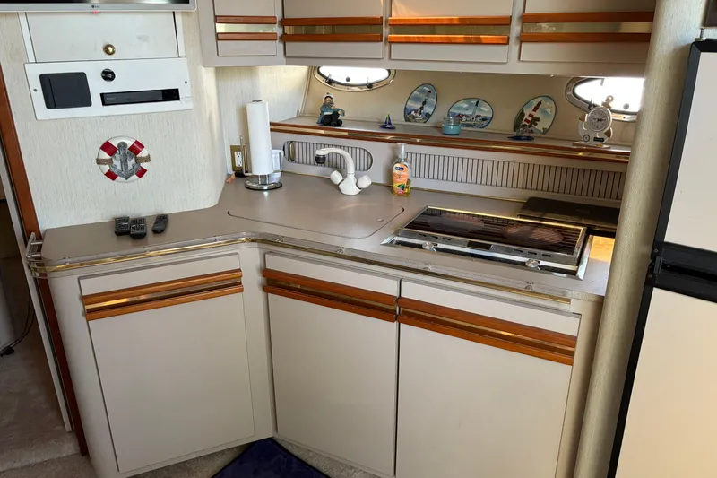 Slide: The Image of 1989 Cruisers 3670 yacht kitchen with stove, sink, and decorative plates. - 10