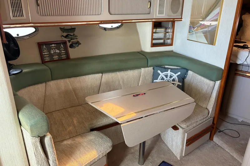 Slide: The Image of 1989 Cruisers 3670 yacht interior with cozy seating and foldable table. - 11