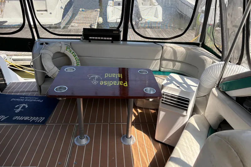 Slide: The Image of Interior of 1989 Cruisers 3670 yacht with table, seating, and air conditioning unit. - 5