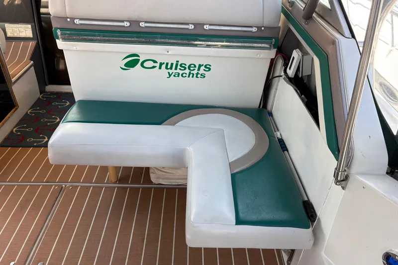 Slide: The Image of 1989 Cruisers 3670 yacht interior with green and white seating, showcasing brand logo. - 6