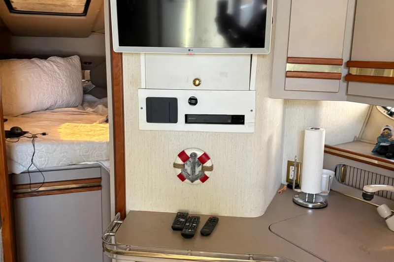 Slide: The Image of Interior of 1989 Cruisers 3670 yacht with TV, bed, and kitchen area. - 9
