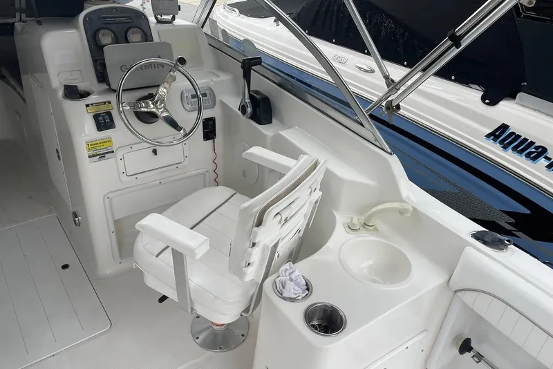Slide: The Image of 2009 Sea Hunt Escape 220 LE boat cockpit with steering wheel and seating. - 10