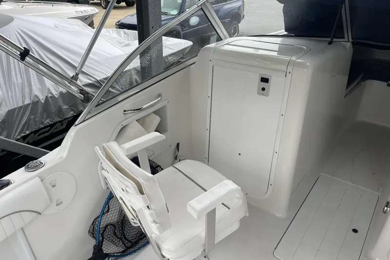 Slide: The Image of 2009 Sea Hunt Escape 220 LE boat interior with white seating and storage compartment. - 11