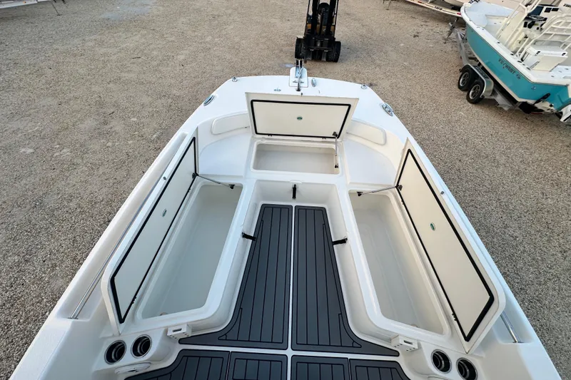 Slide: The Image of 2022 World Cat 235 CC boat with open storage compartments and sleek deck design. - 11
