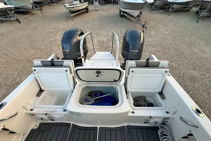 Slide: The Image of 2022 World Cat 235 CC boat with dual Yamaha 150 engines, open storage compartments. - 16
