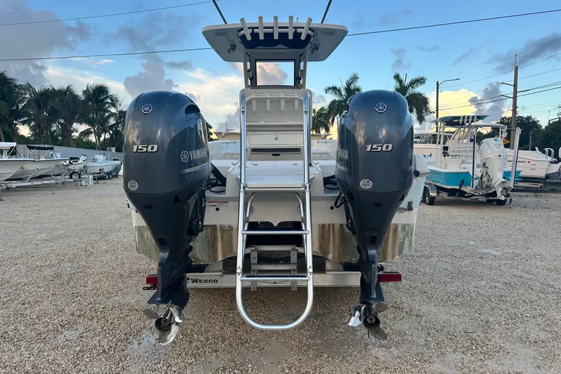 Slide: The Image of 2022 World Cat 235 CC boat with dual Yamaha 150 engines, parked on gravel. - 4