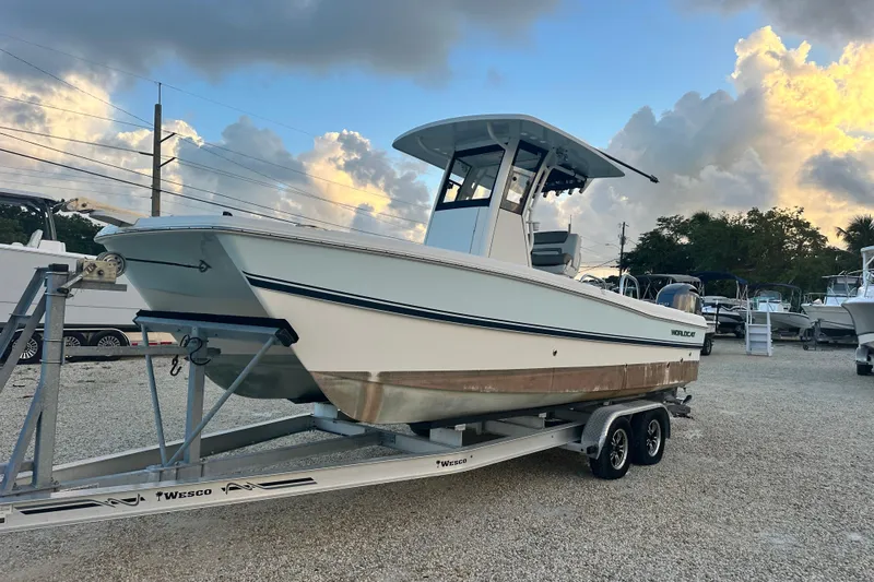 Slide: The Image of 2022 World Cat 235 CC boat on trailer under cloudy sky. - 7