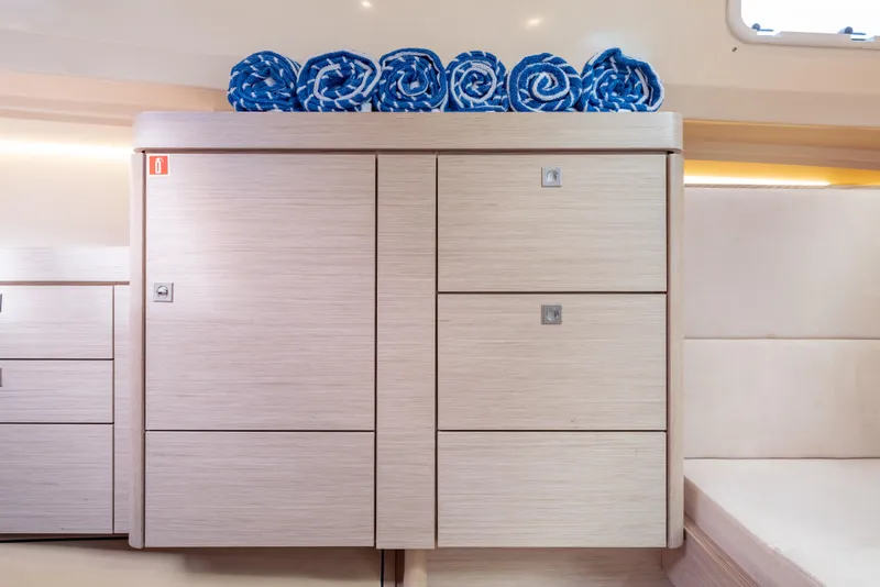 Slide: The Image of Modern interior of 2021 Fjord 40 Open yacht with wooden cabinetry and rolled blue towels. - 20