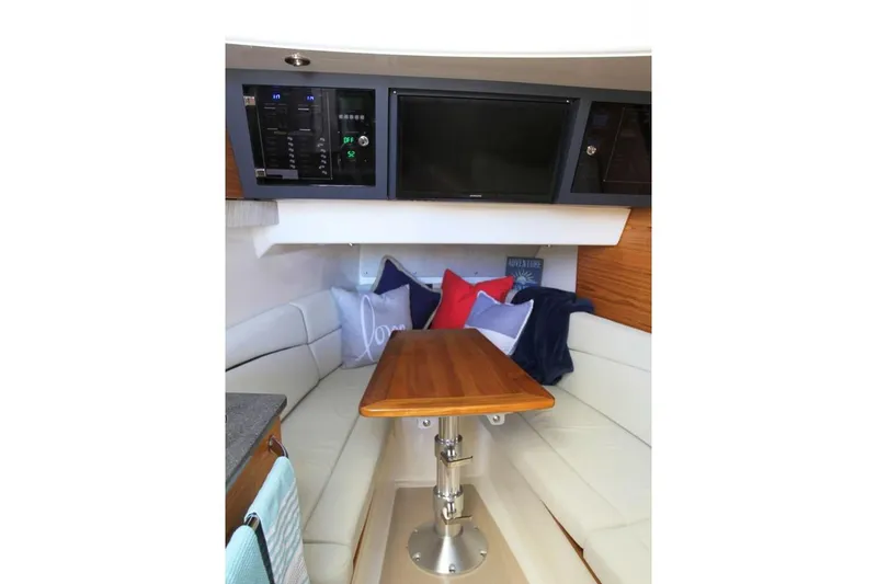 Slide: The Image of Manufacturer Provided Image: Interior of 2019 Boston Whaler 380 Realm with seating area and wooden table. - 16