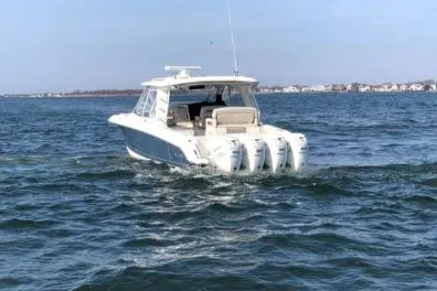 Slide: The Image of 2019 Boston Whaler 380 Realm boat cruising on open water with four engines. - 7