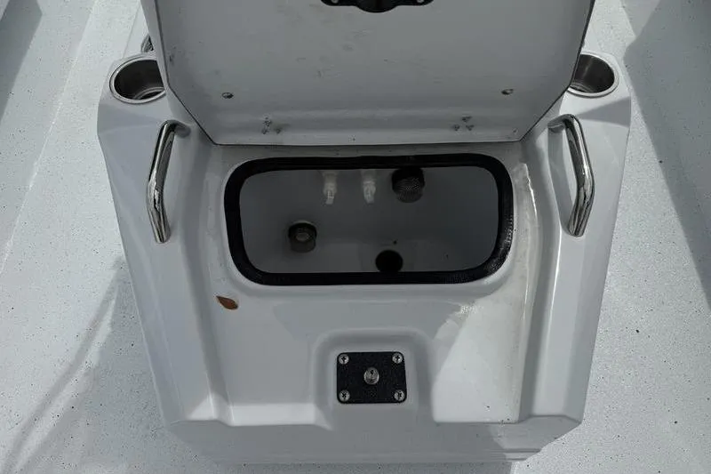 Slide: The Image of Open storage compartment on 2026 Xpress H22B boat, featuring cup holders and handles. - 11