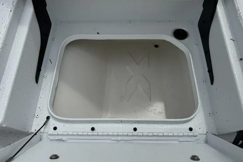 Slide: The Image of 2026 Xpress H22B boat storage compartment with hinged lid and drainage hole. - 16
