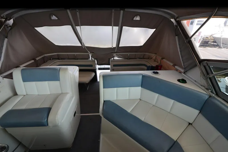 Slide: The Image of Interior of 1990 Slick Craft 310 SC boat with cushioned seating and canopy. - 10