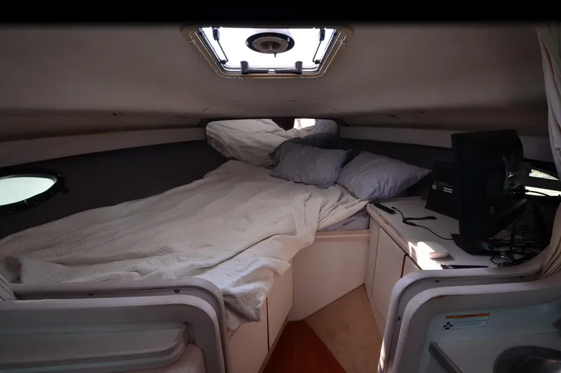 Slide: The Image of 1990 Slick Craft 310 SC cabin interior with bed, porthole, and desk area. - 16