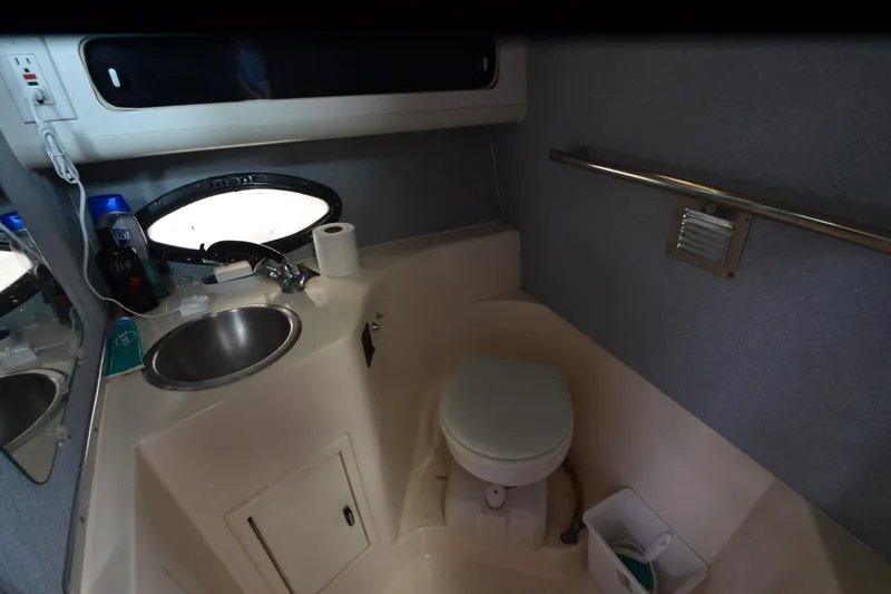 Slide: The Image of 1990 Slick Craft 310 SC boat bathroom with sink, toilet, and window. - 21