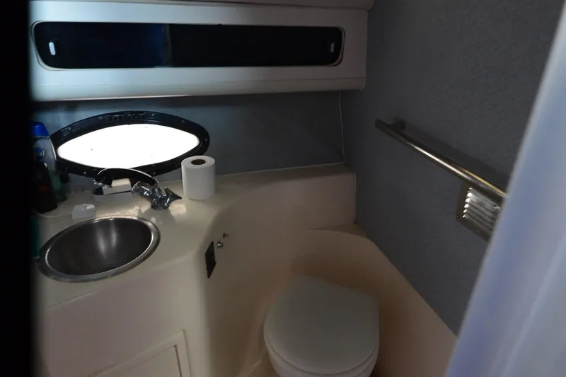 Slide: The Image of 1990 Slick Craft 310 SC boat bathroom with sink, toilet, and window. - 22