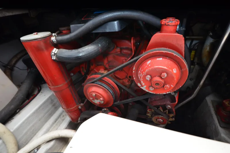 Slide: The Image of Engine compartment of a 1990 Slick Craft 310 SC boat, featuring red mechanical components. - 23