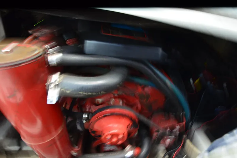 Slide: The Image of Blurry image of a 1990 Slick Craft 310 SC engine with red components and hoses. - 24