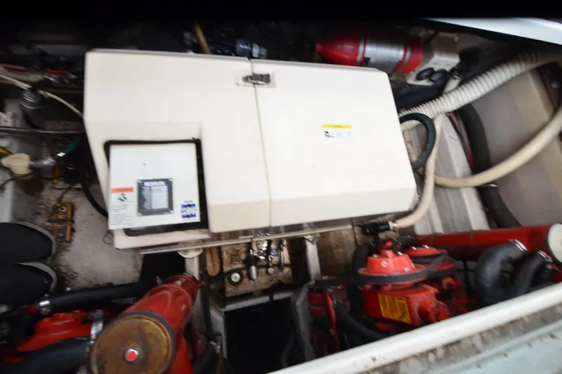 Slide: The Image of Engine compartment of a 1990 Slick Craft 310 SC boat, featuring mechanical components and hoses. - 25