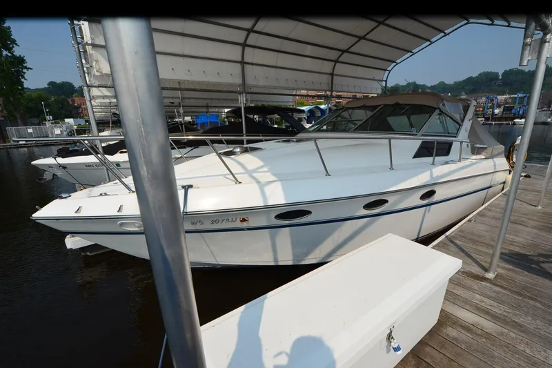 Slide: The Image of 1990 Slick Craft 310 SC boat docked under a canopy on a sunny day. - 3