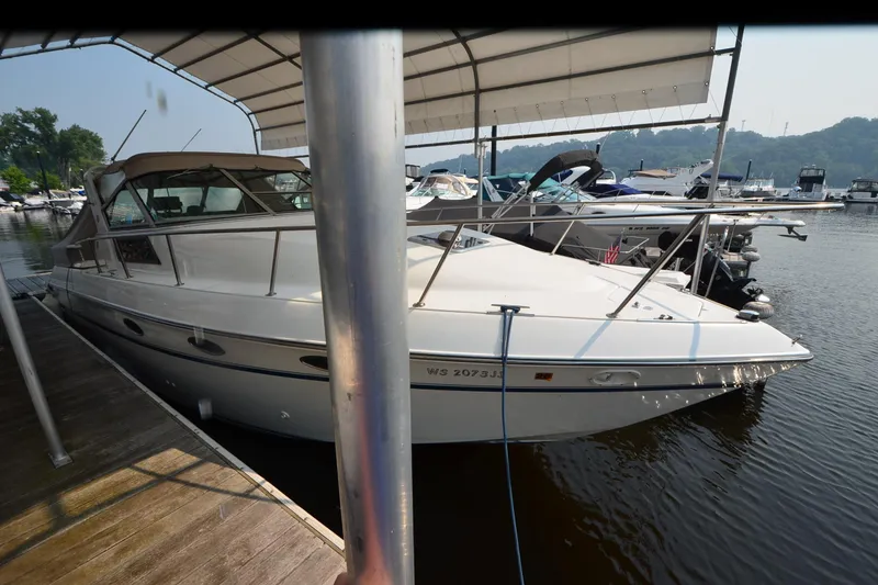 Slide: The Image of 1990 Slick Craft 310 SC boat docked at marina under canopy. - 5