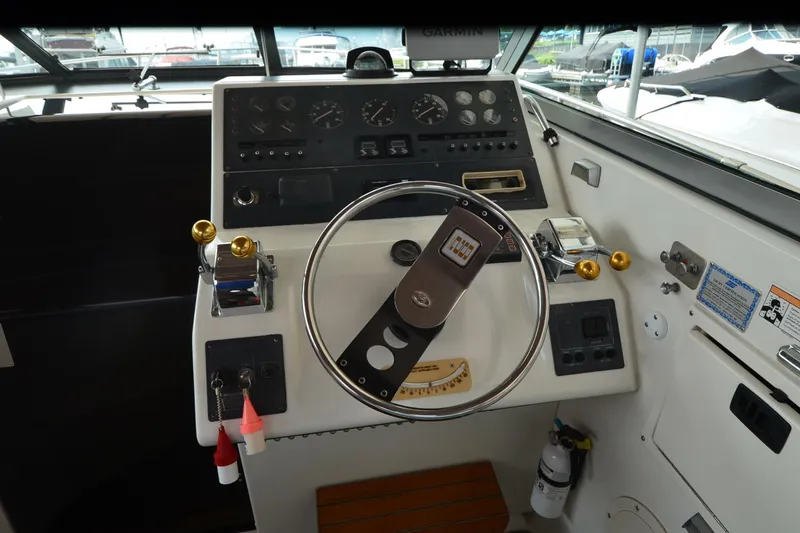 Slide: The Image of Cockpit of 1990 Slick Craft 310 SC boat with steering wheel and control panel. - 8