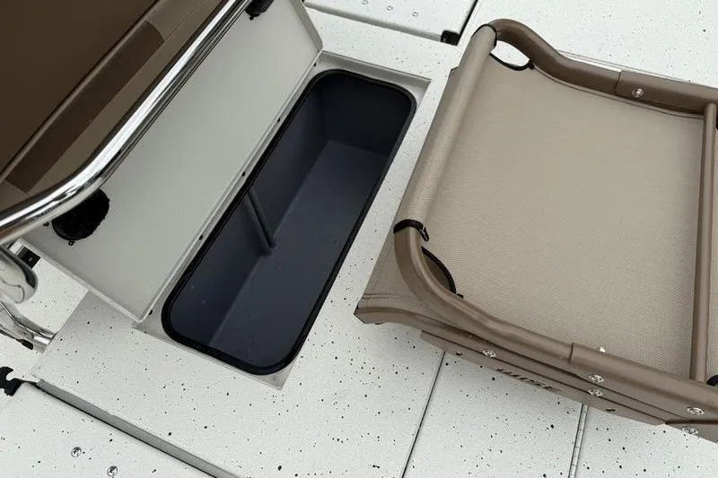 Slide: The Image of 2026 Xpress H22B boat storage compartment and foldable seat on speckled deck. - 17