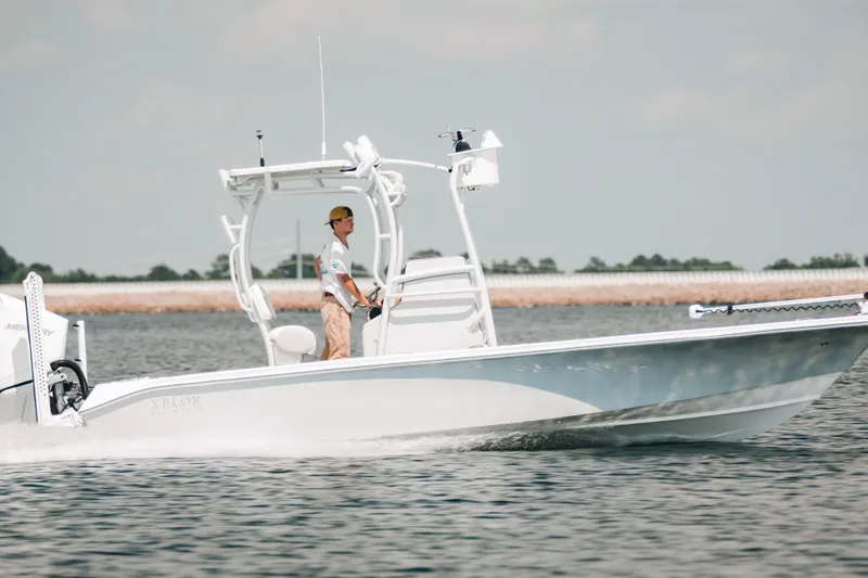 Slide: The Image of 2021 Xplor x24 Andros boat cruising on water with a person at the helm. - 12